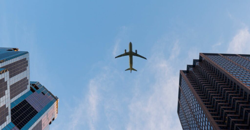 Airplane flies over Chicago's modern skyscrapers against a clear sky, highlighting urban architecture.